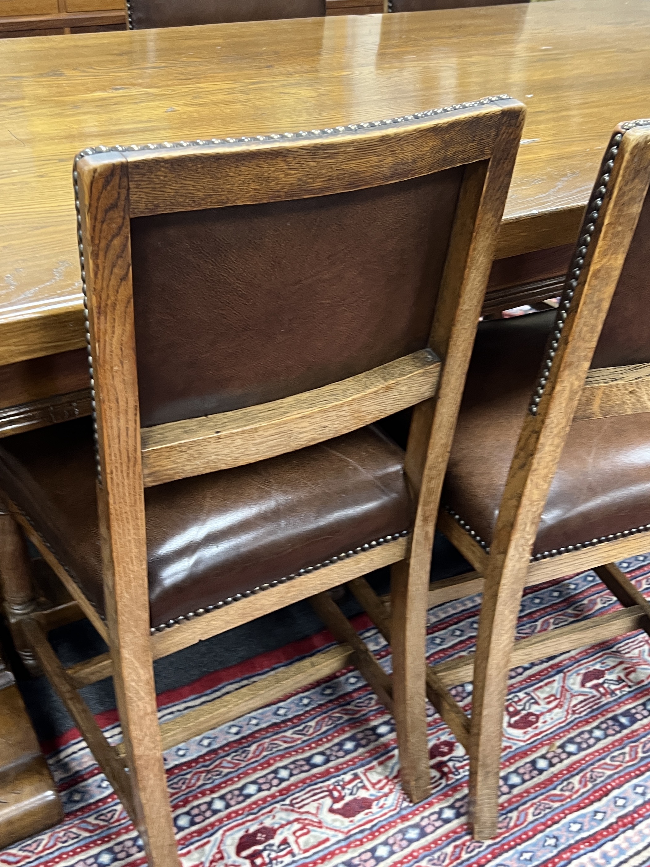 An 18th century style oak refectory dining table, length 198cm, height 76cm and eight oak dining chairs, two with arms